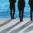 Four people are standing in front of the ocean