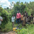 Area residents watch as Florida State University graduate student Travis Drake collects water samples from a stream in the Democratic Republic of Congo.