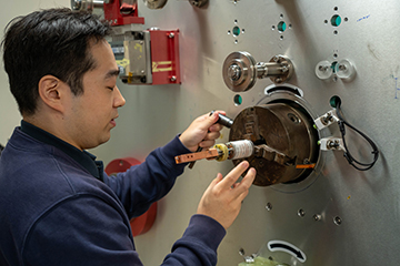 A researcher places a high temperature superconducting coil on a winding machine at the Applied Superconductivity Center