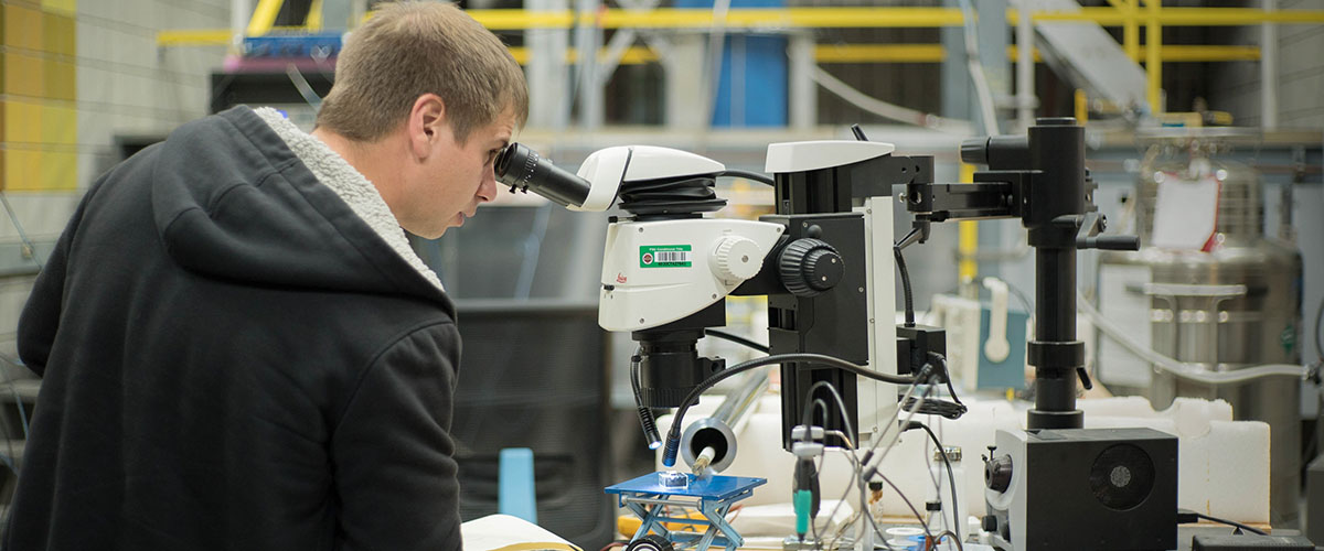 User working on probe sample under microscope